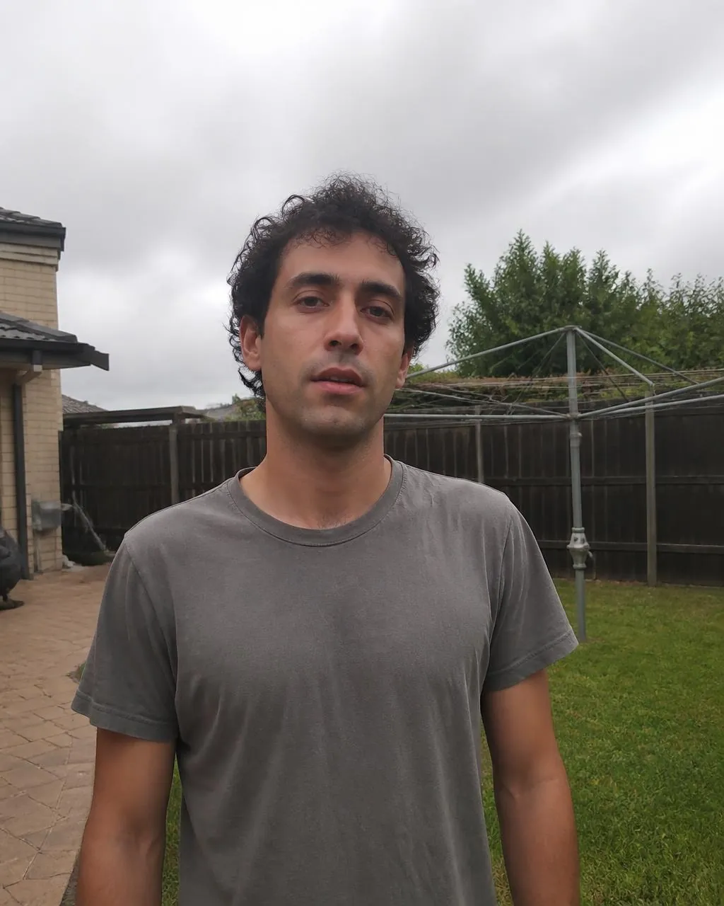 Everyday backyard photo of a young Aussie bloke in a grey tee